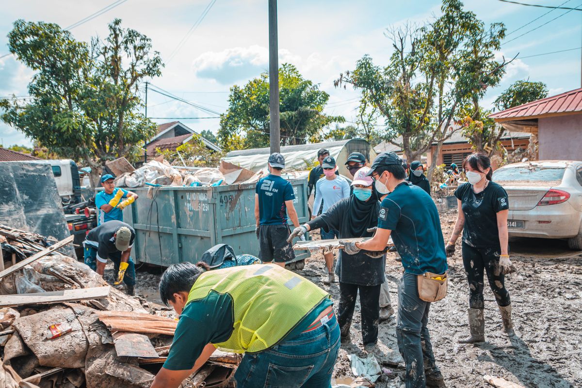 Relawan di Indonesia bekerja sama membersihkan puing