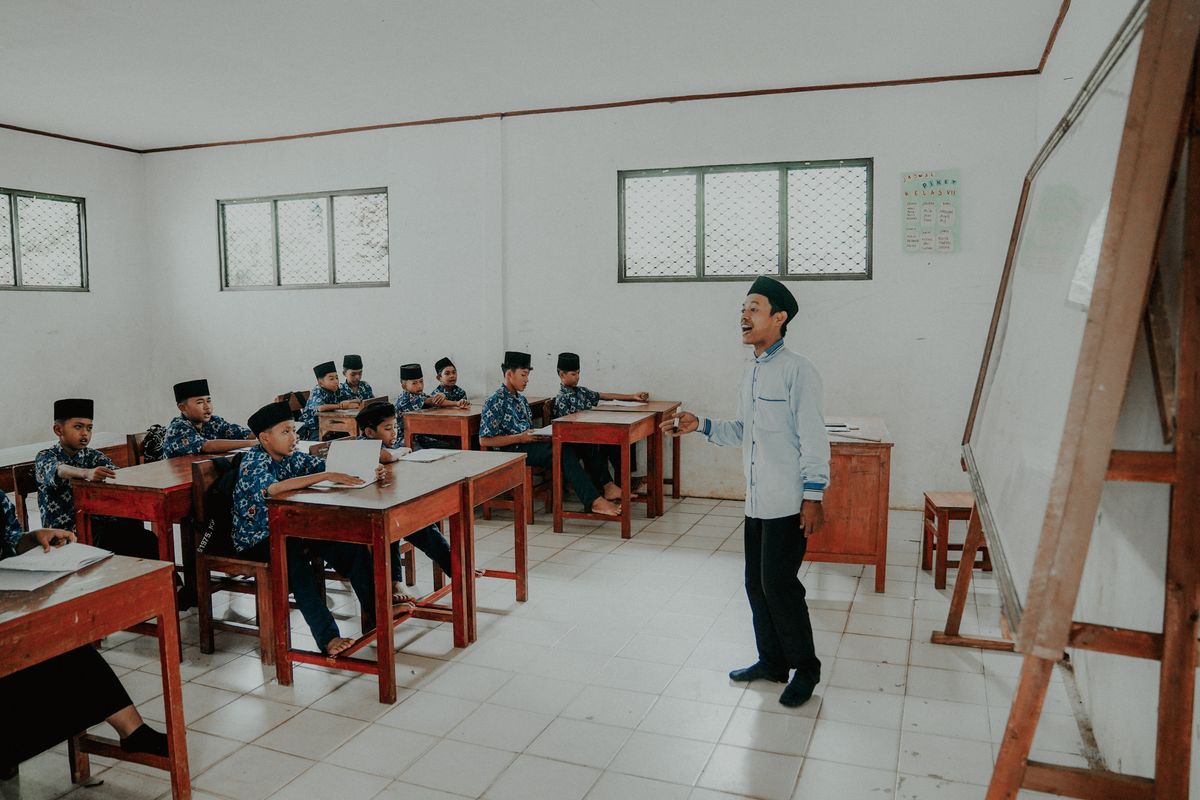 Guru mengajar sekelompok siswa di sekolah Indonesia