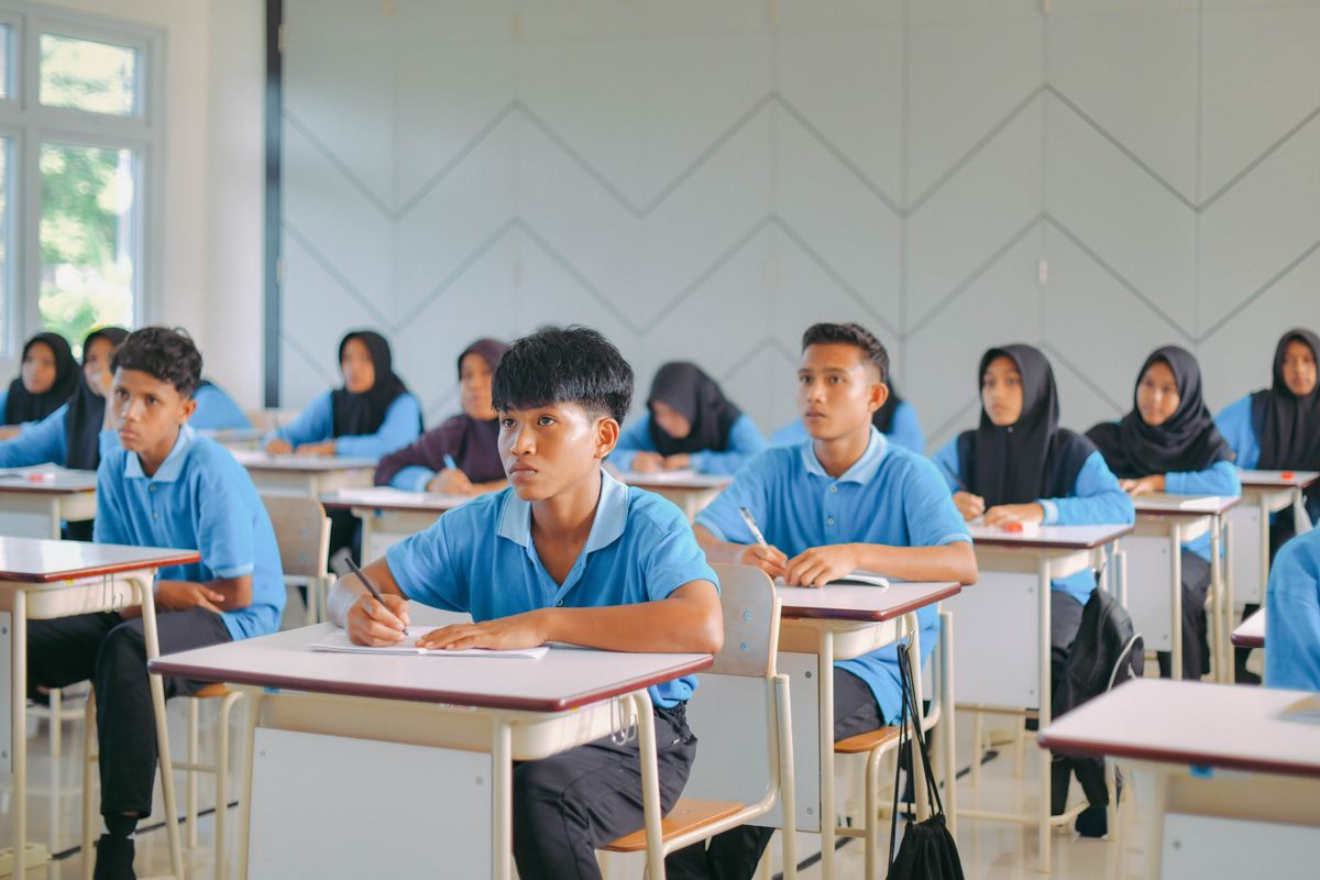 Siswa Indonesia belajar dengan penuh perhatian di dalam kelas